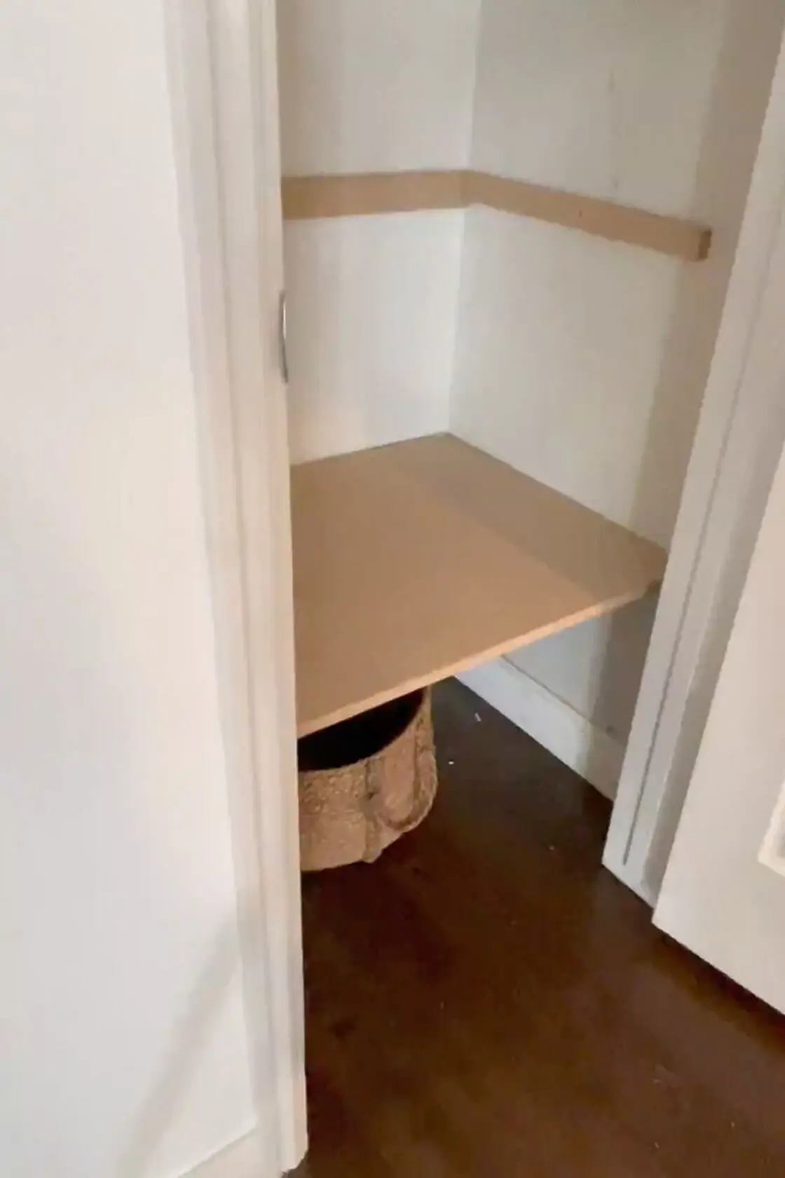 A newly installed wooden shelf in a small closet, supported by wooden cleats for a sturdy and functional storage solution.